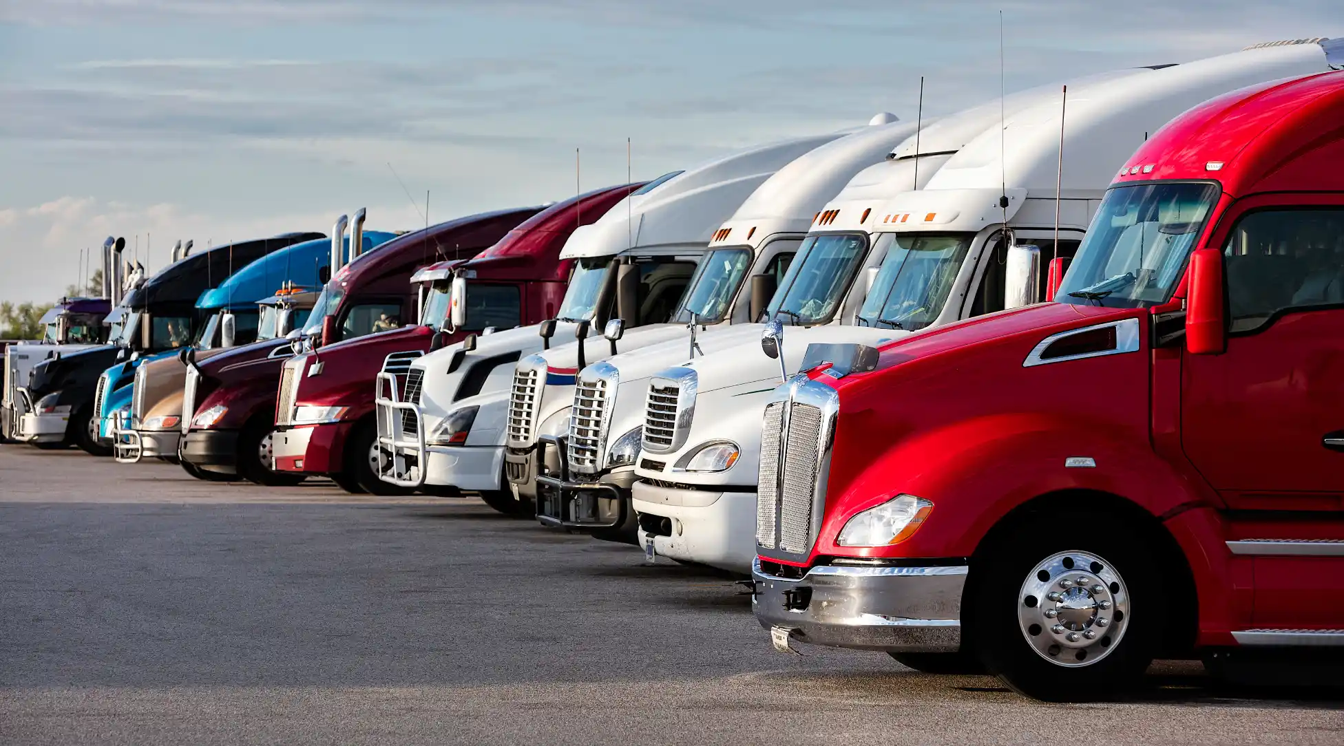 Fleet of professional semi-trucks lined up at trucking terminal - IRS Form 2290 e-filing service for heavy highway vehicles